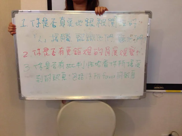 讀書會成員舉著寫滿問題的白板